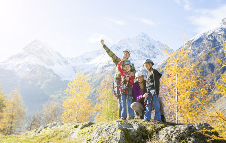 Familie mit Kletterausrüstung vor einer Berglandschaft